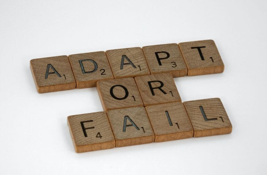 scrabble pieces read "adapt or fail" - advantages and disadvantages of working abroad 