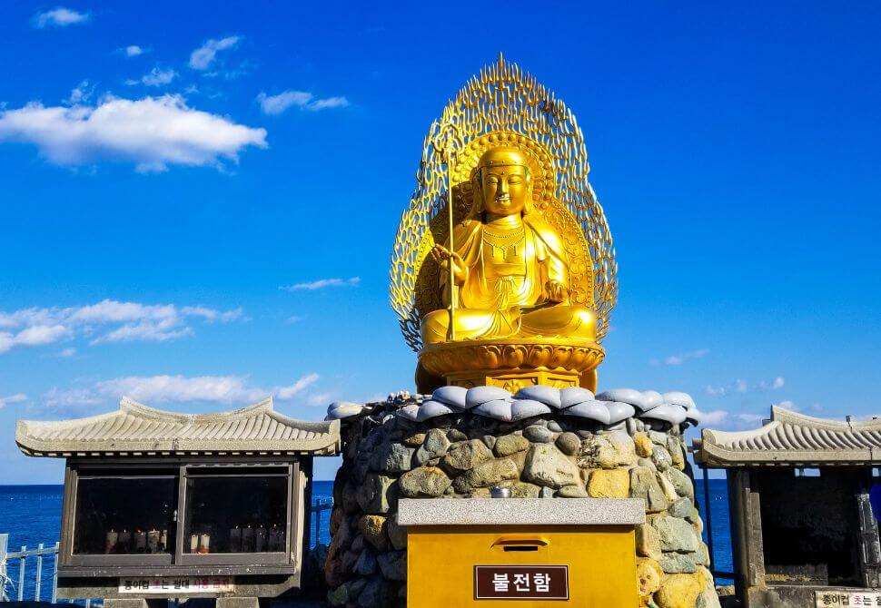 A golden statue of Jijang Bosal at the sunrise platform of Haedong Yonggungsa temple in Busan 
