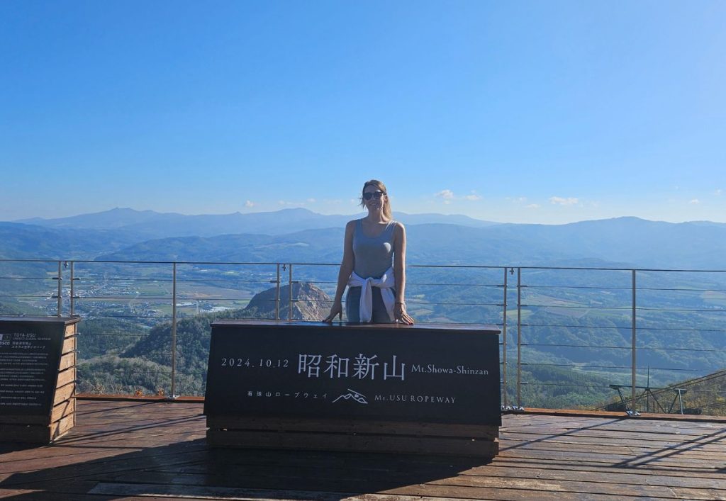 me standing behind a sign at the top of Mt Usu