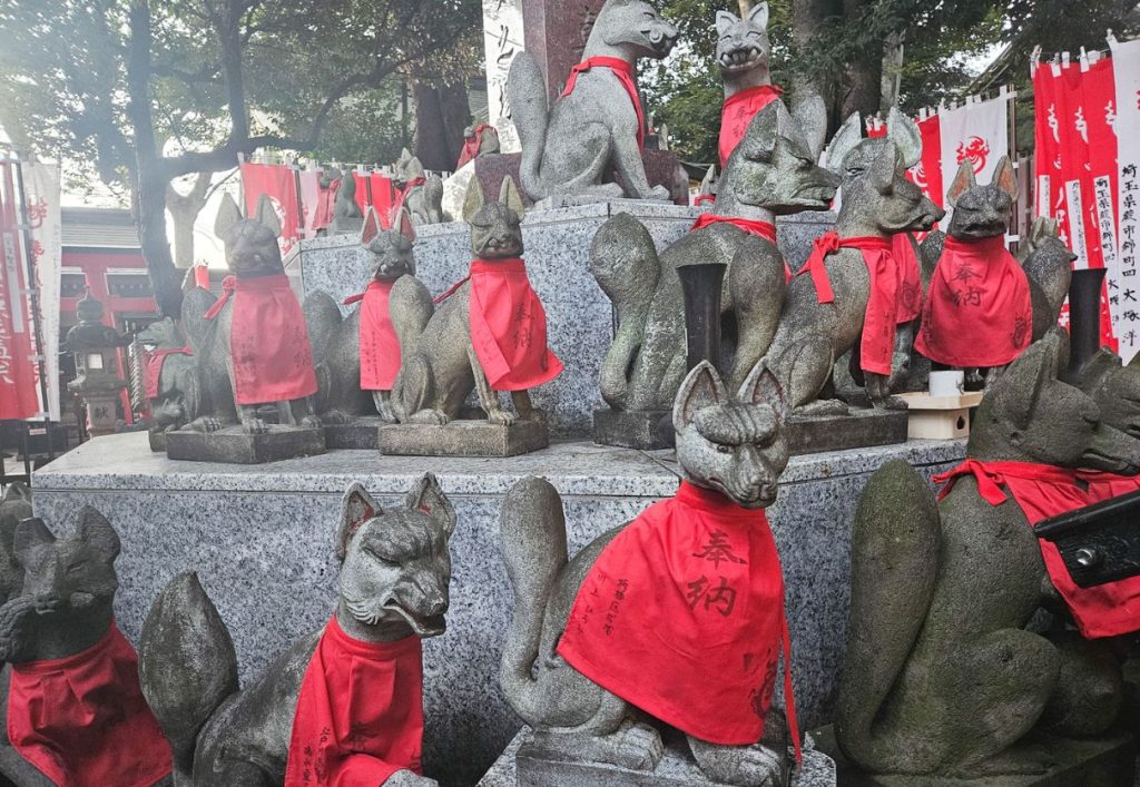 the foxes with red jackets at the Toyokawa Inari Annex Fox Shrine in Tokyo