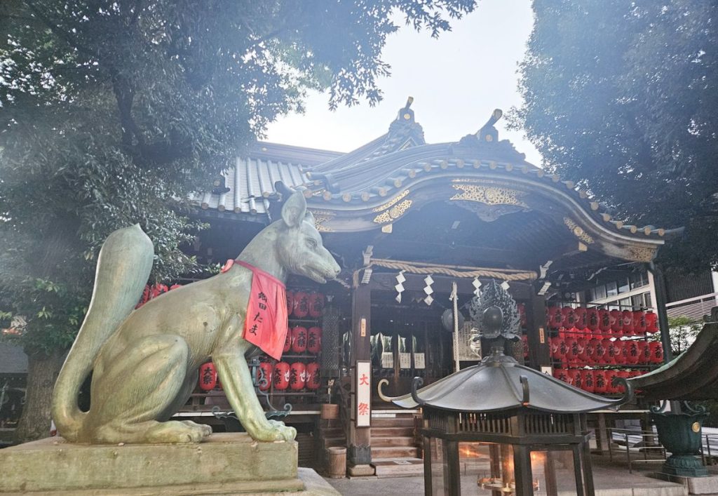 Toyokawa Inari Tokyo Annex largest temple structure with a statue of a fox outside