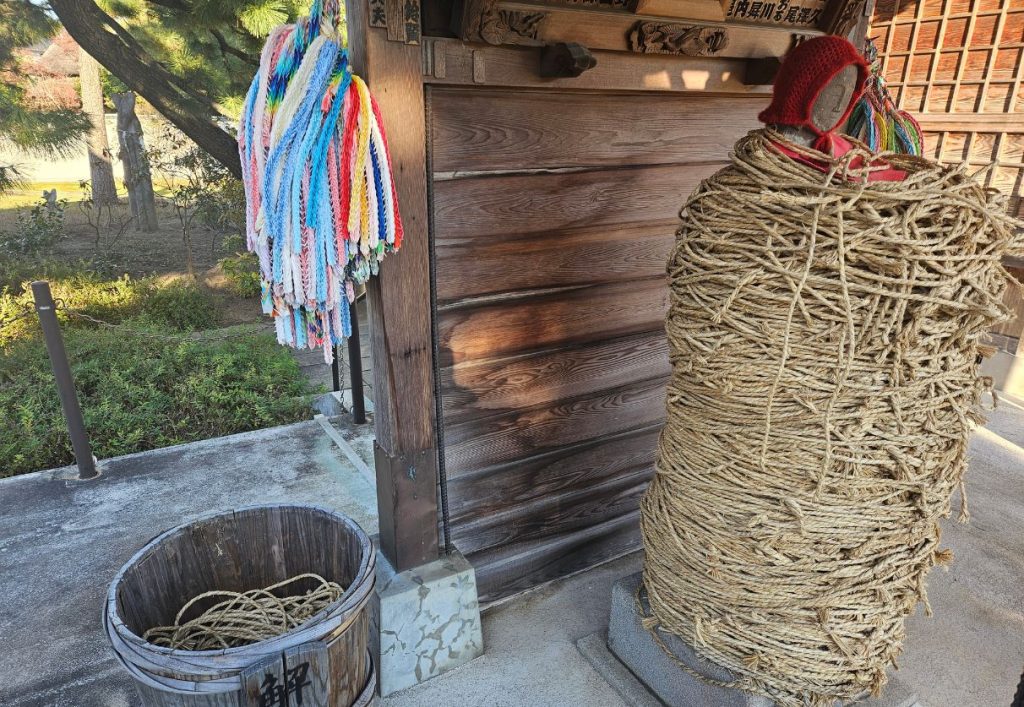 Jizo and the bucket of removed ropes at Nanzoin Shrine Tokyo